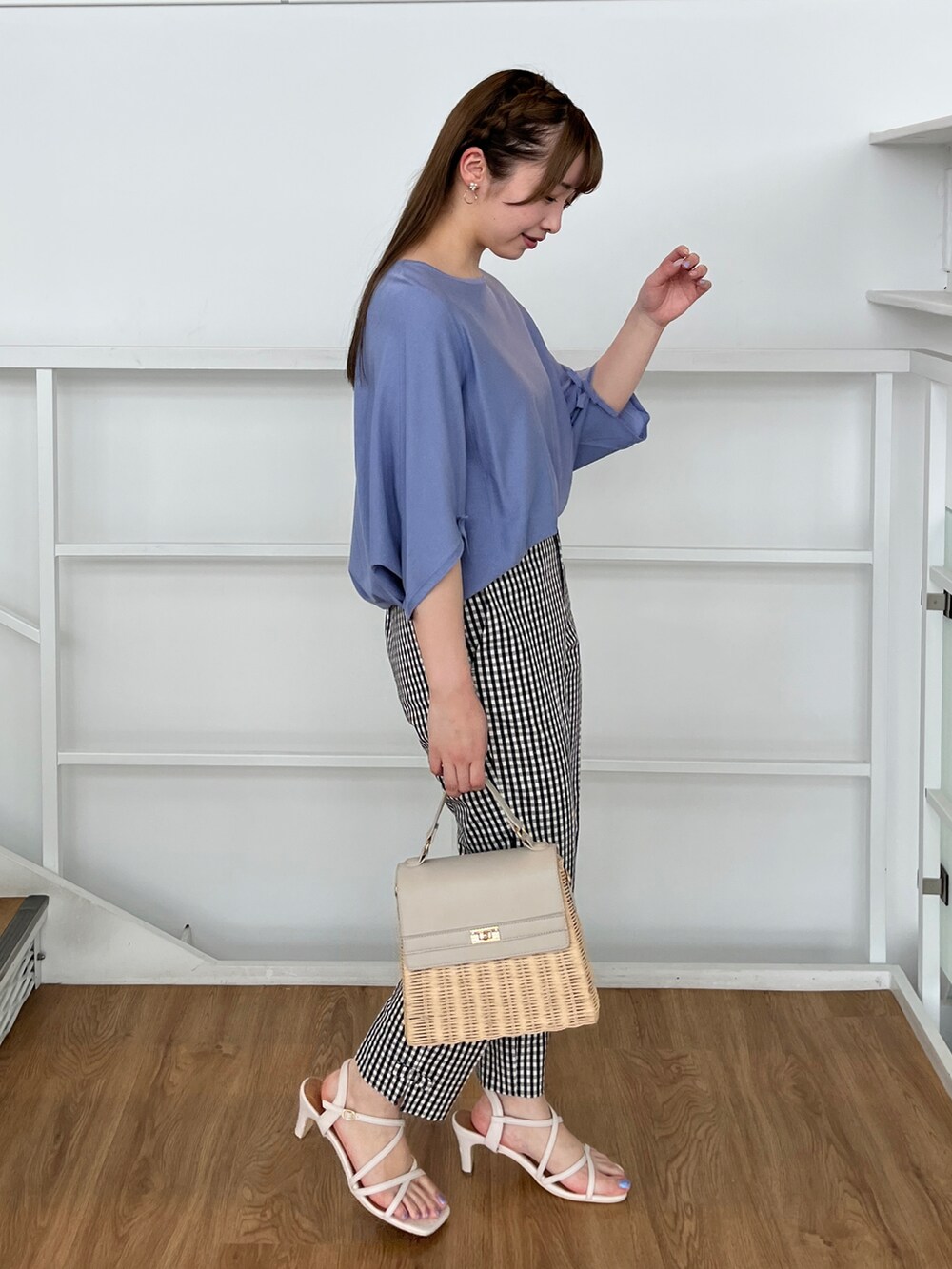 ブルー系のニット/セーター、ブラック系のその他パンツ、グレー系のショルダーバッグを着用したレディースの夏コーディネートの2枚目の写真