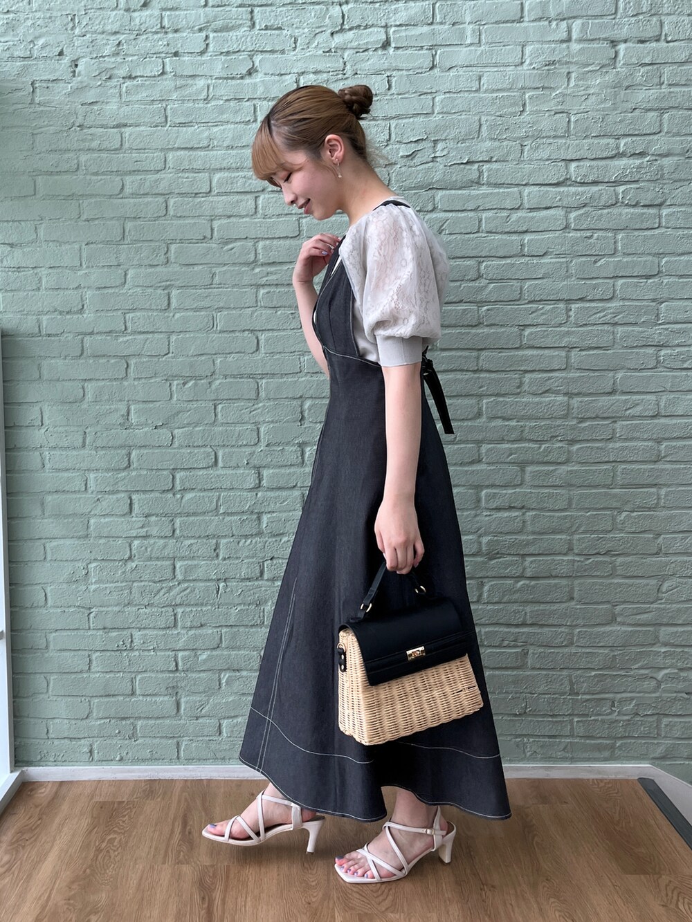 グレー系のニット/セーター、ブラック系のスカート、ブラック系のショルダーバッグを着用したレディースの夏コーディネートの2枚目の写真