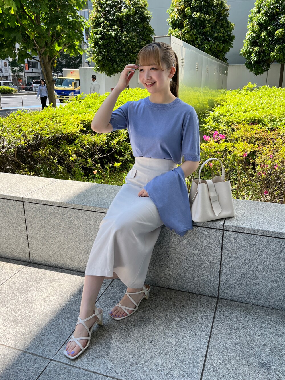 ブルー系のニット/セーター、ブルー系のカーディガン/ボレロ、ベージュ系のスカートを着用したレディースの春コーディネートの5枚目の写真