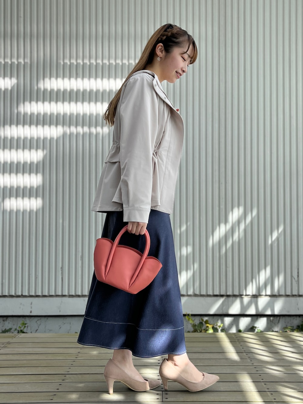 グレー系のブルゾン、ホワイト系のTシャツ/カットソー、ブルー系のスカートを着用したレディースの春コーディネートの2枚目の写真