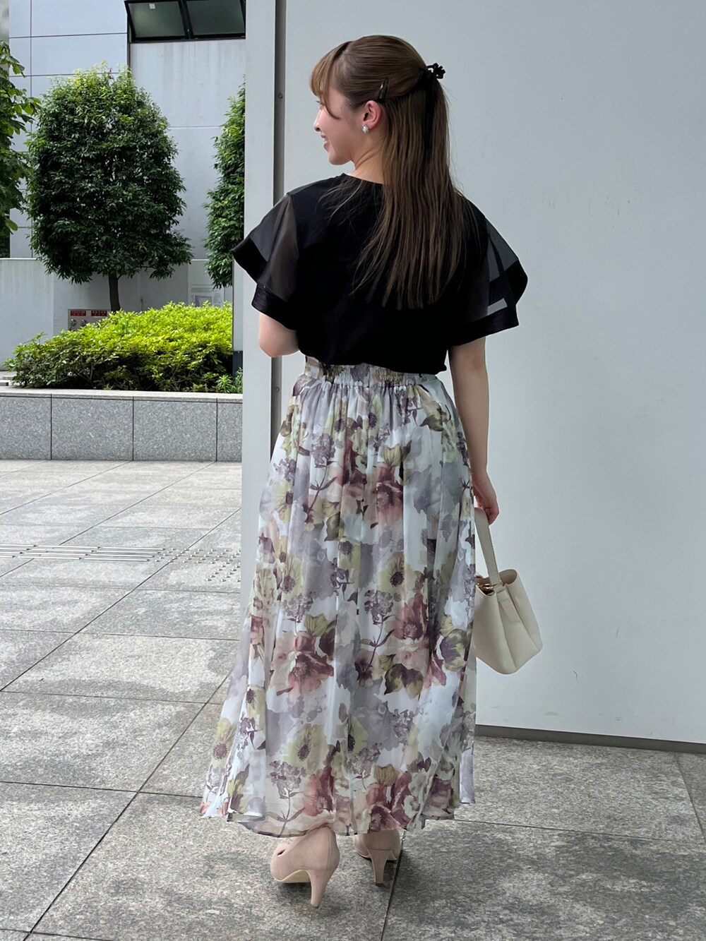 ブラック系のTシャツ/カットソー、グレー系のスカート、ベージュ系のパンプスを着用したレディースの夏コーディネートの3枚目の写真