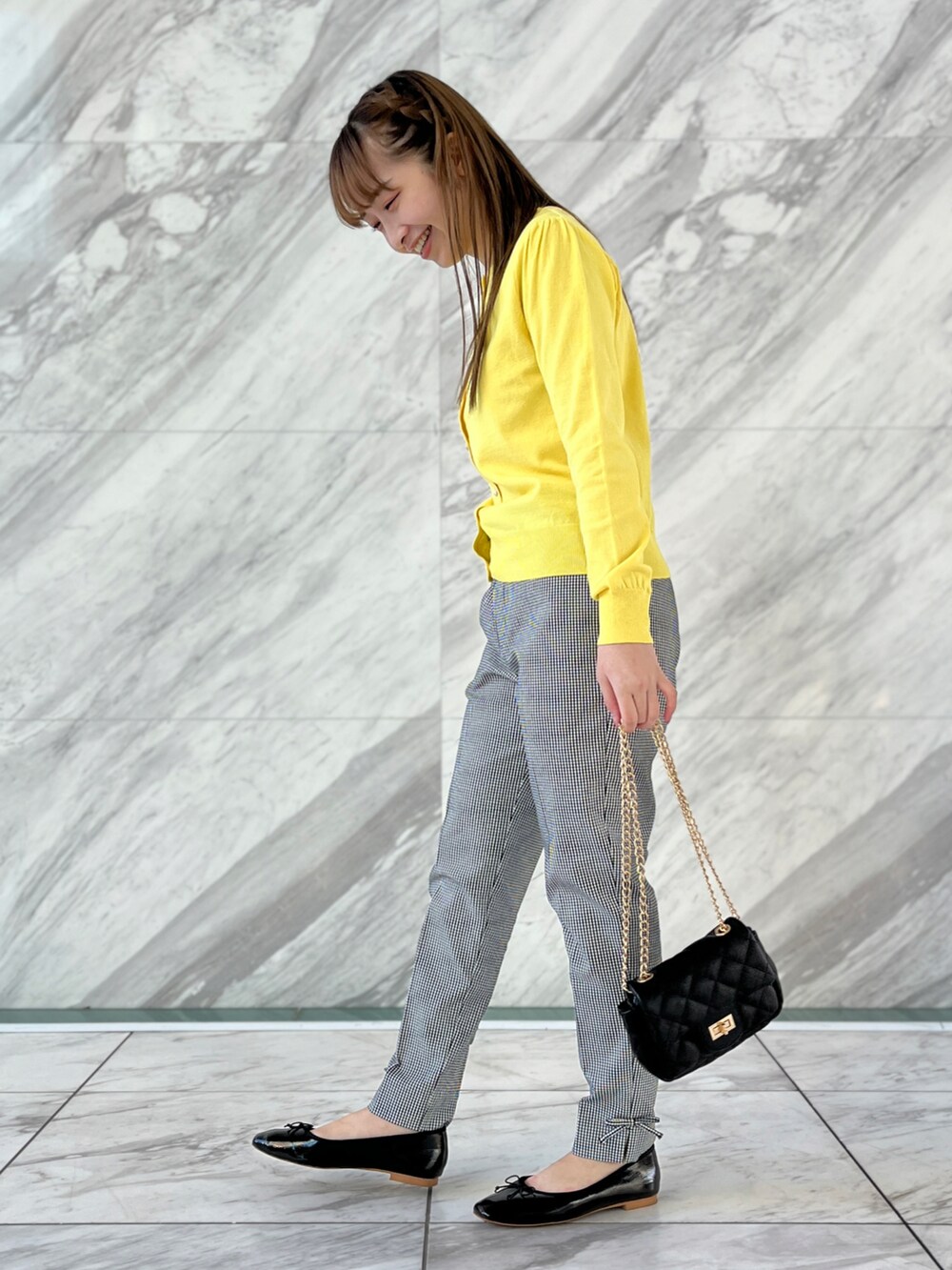 イエロー系のカーディガン/ボレロ、ブラック系のその他パンツ、ブラック系のショルダーバッグを着用したレディースの冬コーディネートの2枚目の写真