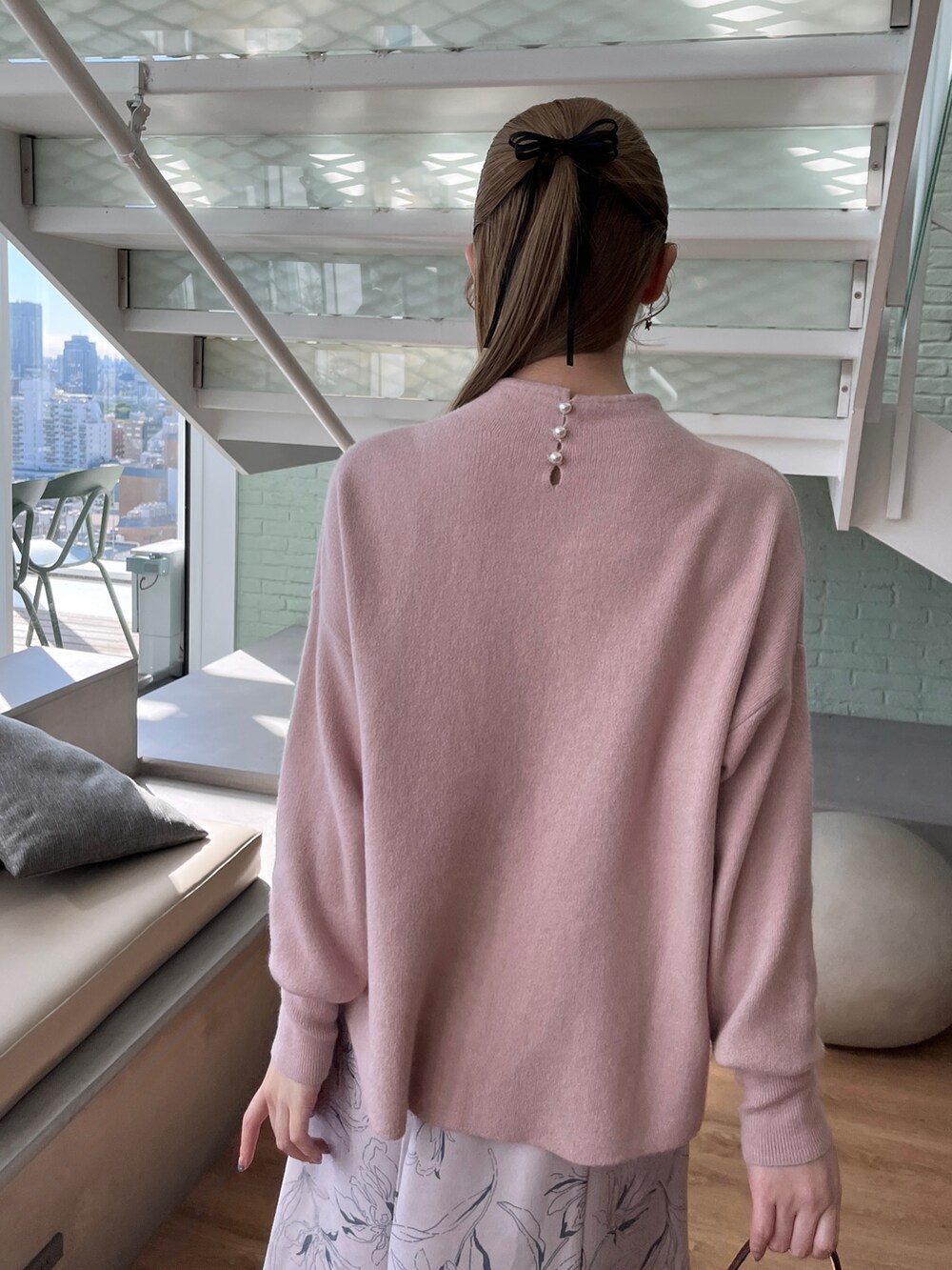 ピンク系のニット/セーター、ベージュ系のスカート、イエロー系のショルダーバッグを着用したレディースの秋コーディネートの4枚目の写真