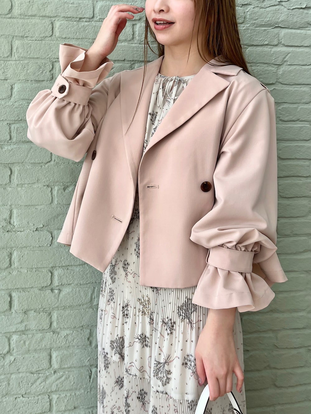 ピンク系のトレンチコート、ベージュ系のワンピースを着用したレディースの冬コーディネートの4枚目の写真