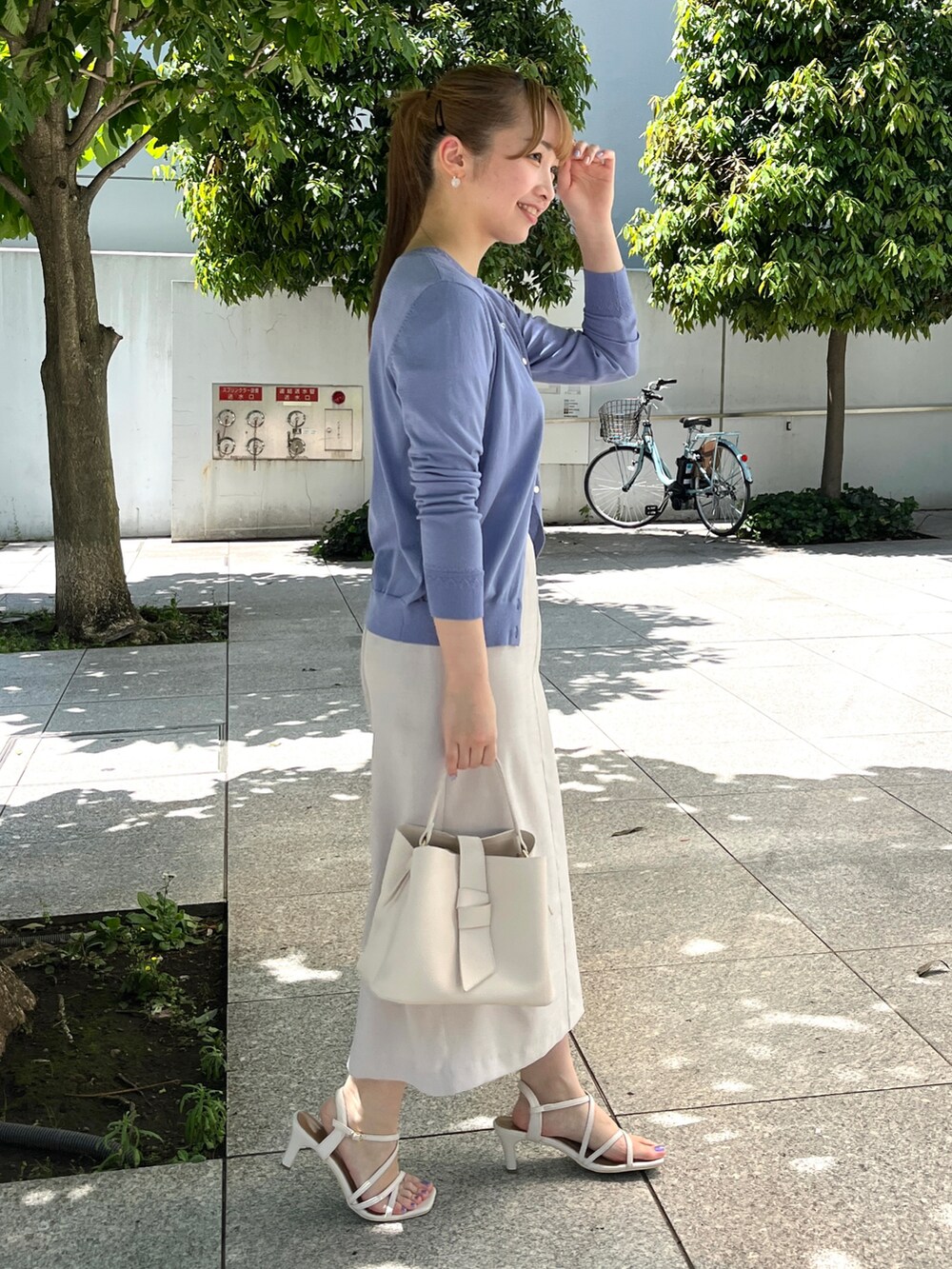 ブルー系のカーディガン/ボレロ、ブルー系のニット/セーター、ベージュ系のスカートを着用したレディースの夏コーディネートの2枚目の写真