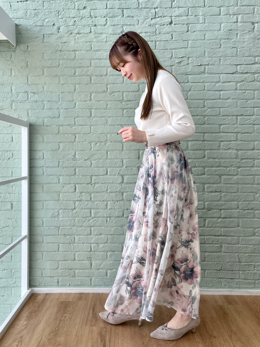 ホワイト系のニット/セーター、ベージュ系のスカートを着用したレディースの冬コーディネートの2枚目の写真