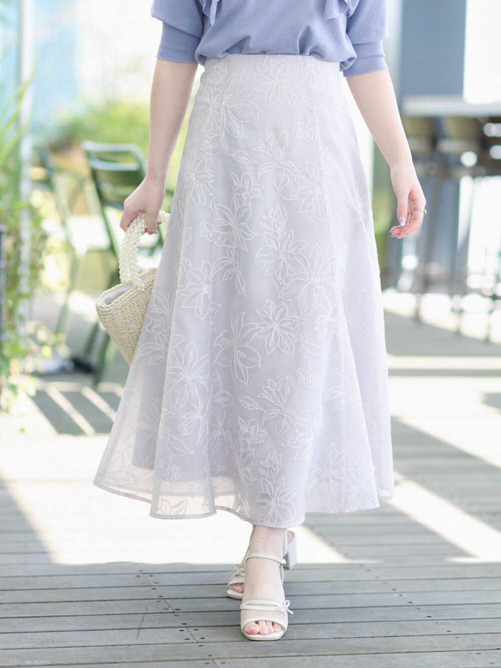 ブルー系のニット/セーター、グレー系のスカートを着用したレディースの春コーディネートの5枚目の写真