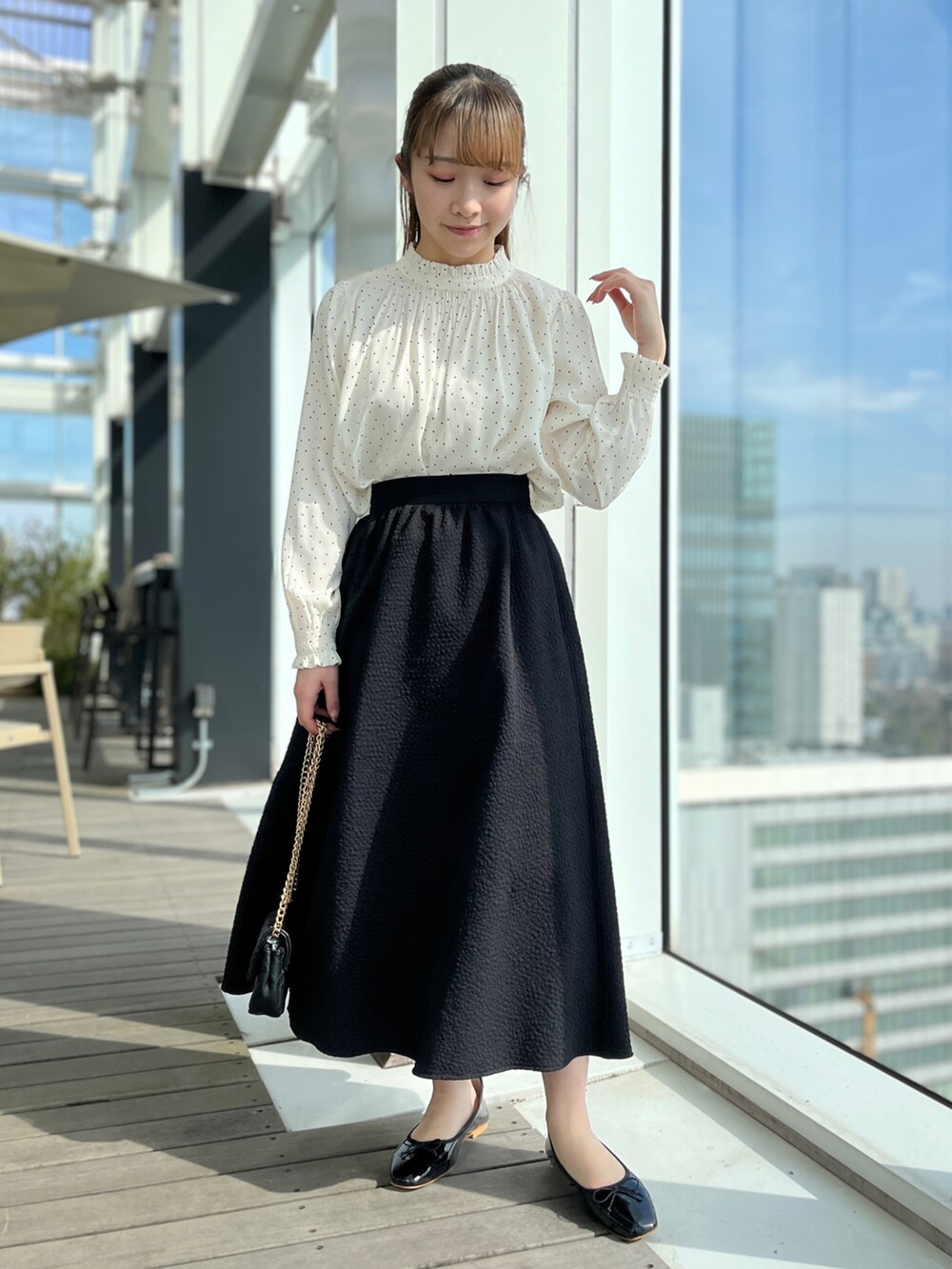 ベージュ系のトレンチコート、ブラック系のスカート、ホワイト系のシャツ/ブラウスを着用したレディースの冬コーディネートの4枚目の写真