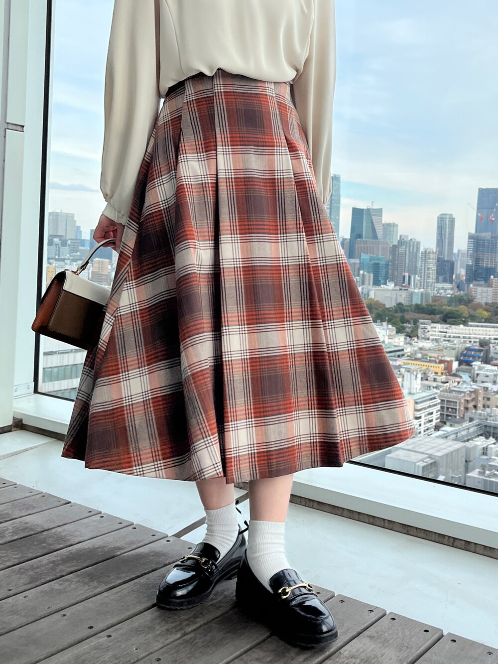 ホワイト系のシャツ/ブラウス、ブラウン系のスカート、ホワイト系のショルダーバッグを着用したレディースの秋コーディネートの4枚目の写真