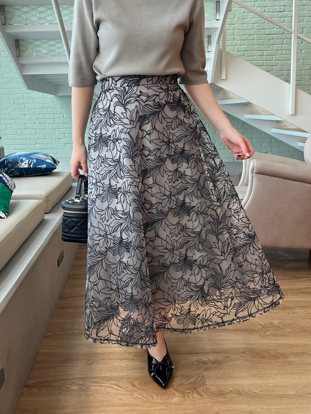 グリーン系のニット/セーター、ブラック系のショルダーバッグ、ブラック系のスカートを着用したレディースの夏コーディネートの5枚目の写真