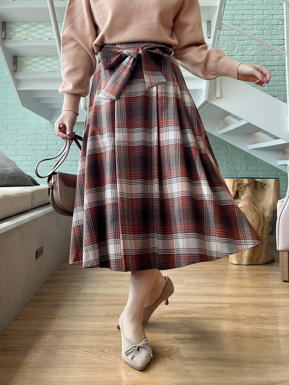 ピンク系のニット/セーター、ブラウン系のスカートを着用したレディースの秋コーディネートの4枚目の写真