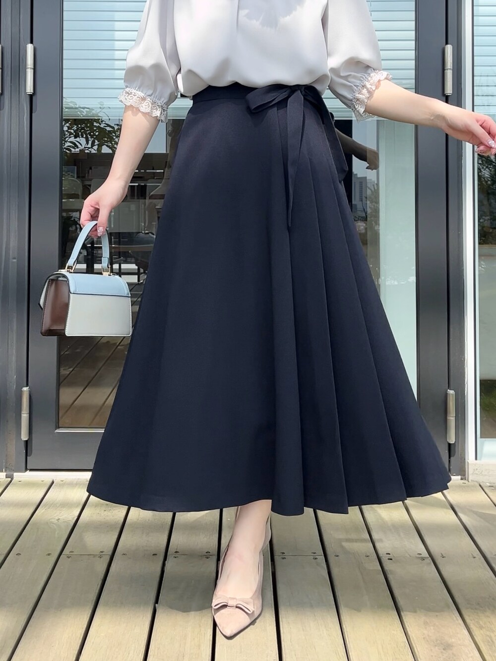 グレー系のシャツ/ブラウス、ブルー系のスカートを着用したレディースの秋コーディネートの5枚目の写真