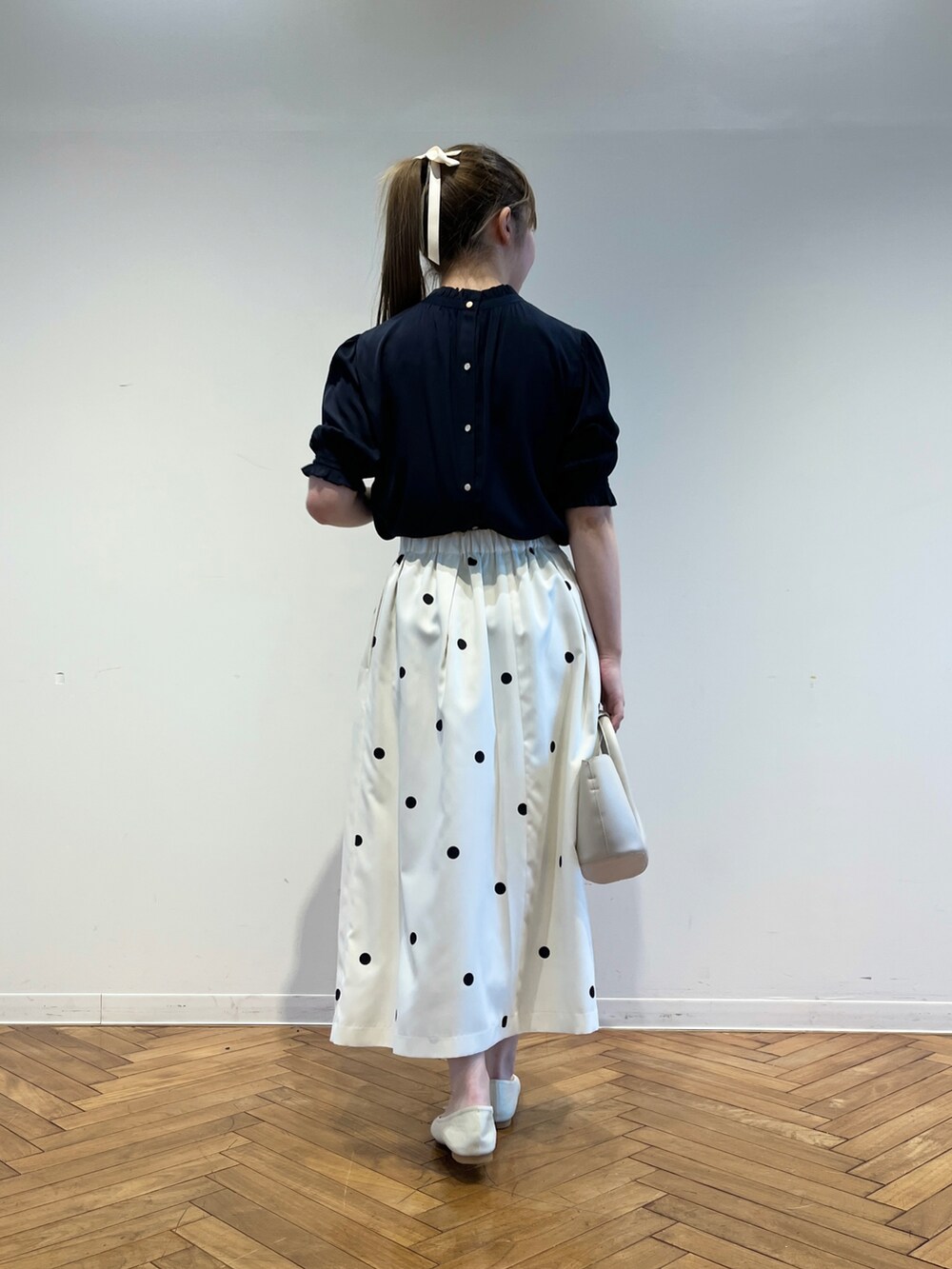 ブルー系のシャツ/ブラウス、ホワイト系のショルダーバッグ、ホワイト系のパンプスを着用したレディースの春コーディネートの3枚目の写真