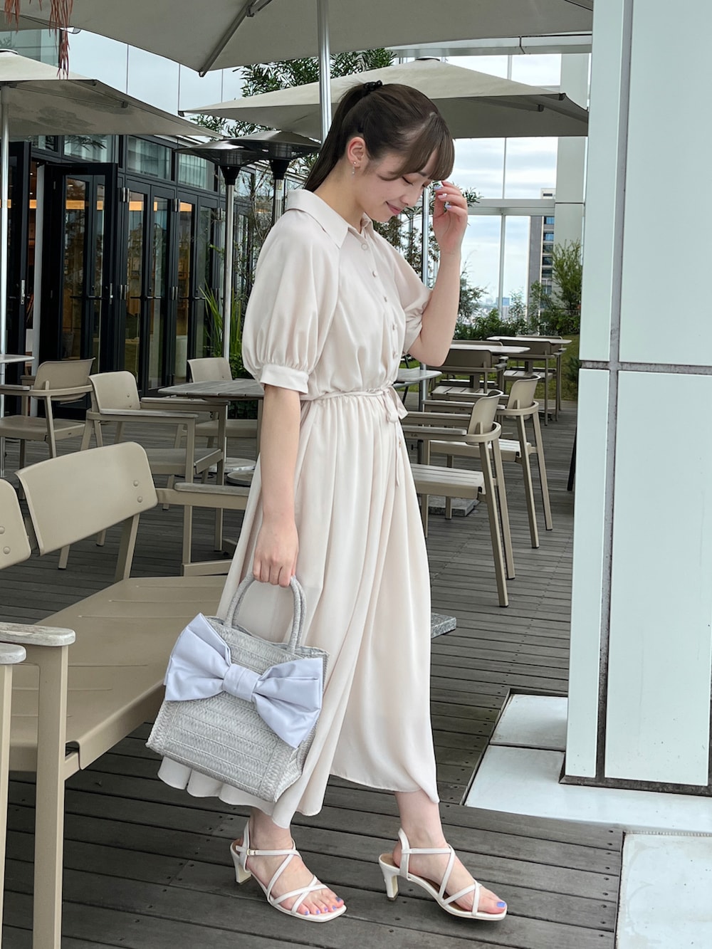 ホワイト系のワンピース、グレー系のトートバッグ、ホワイト系のサンダルを着用したレディースの夏コーディネートの2枚目の写真