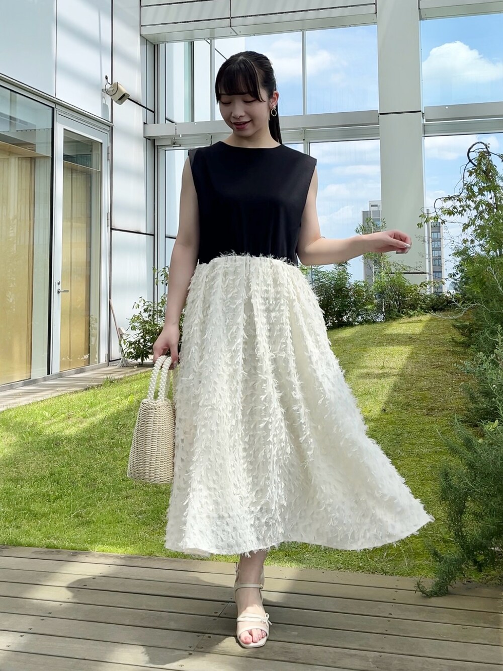 ブラック系のカーディガン/ボレロ、ホワイト系のワンピースを着用したレディースの夏コーディネートの3枚目の写真