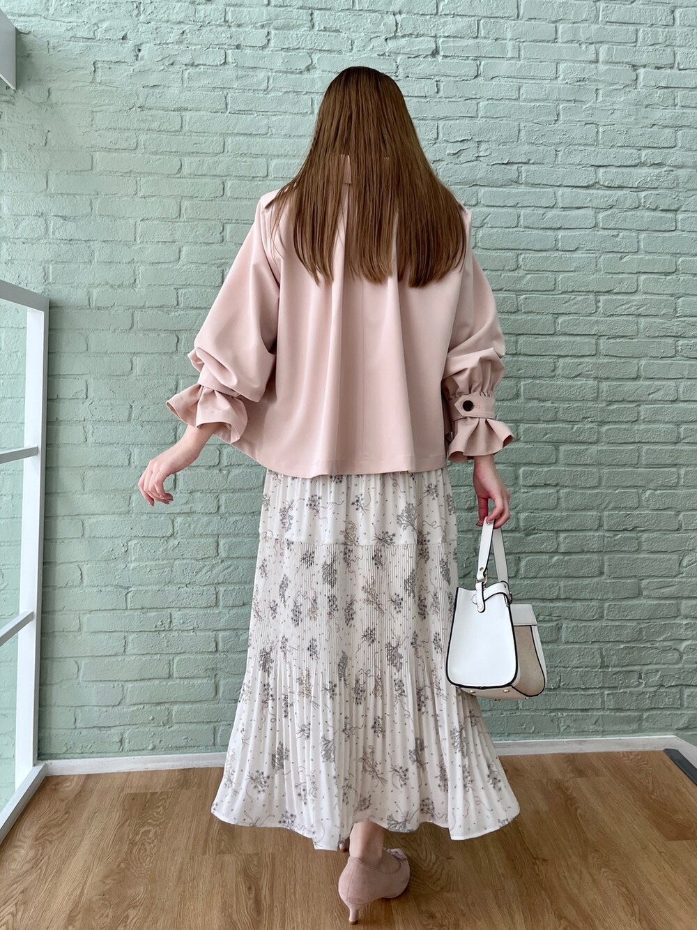 ピンク系のトレンチコート、ベージュ系のワンピースを着用したレディースの冬コーディネートの3枚目の写真