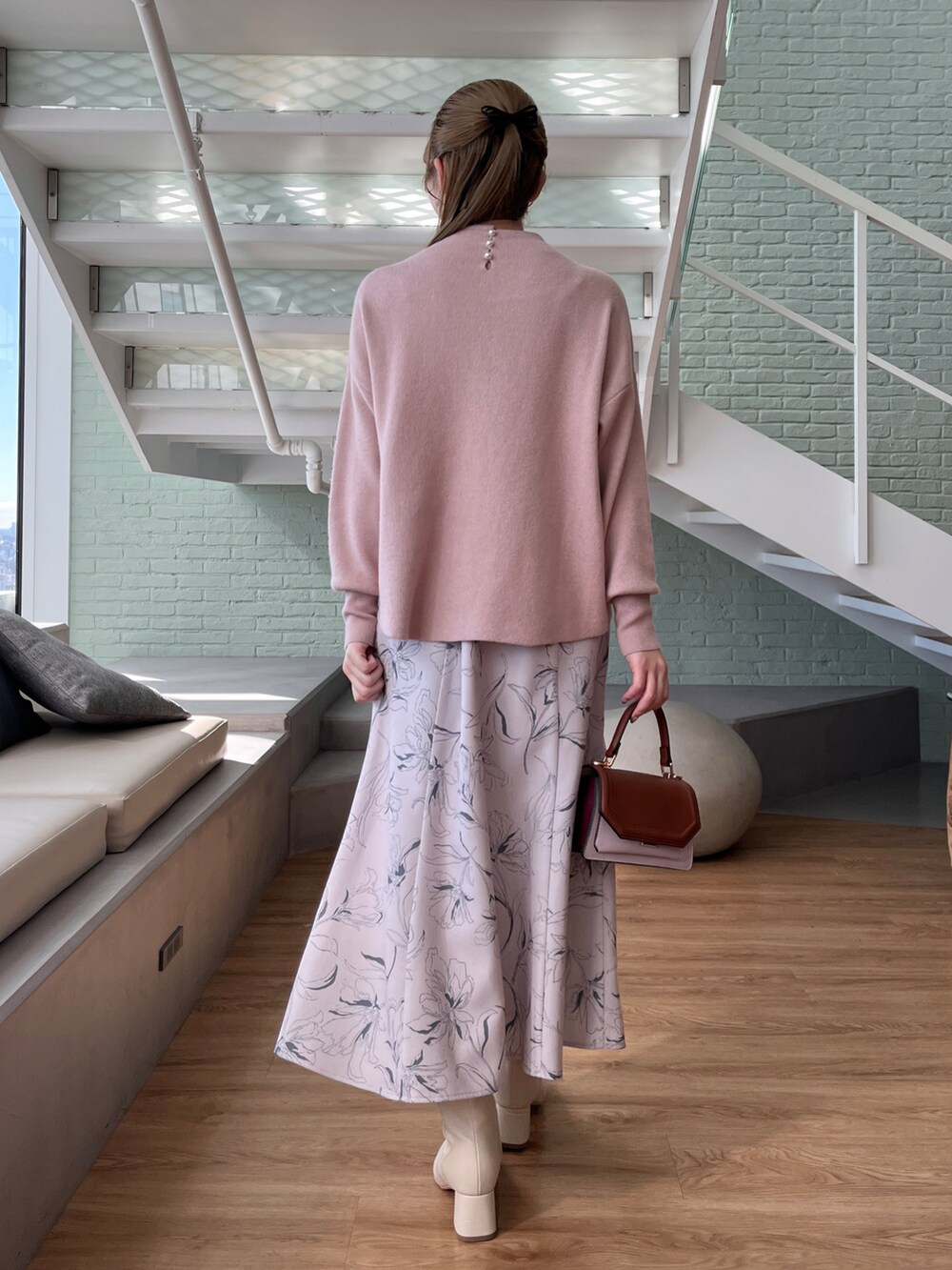 ピンク系のニット/セーター、ベージュ系のスカート、イエロー系のショルダーバッグを着用したレディースの秋コーディネートの2枚目の写真