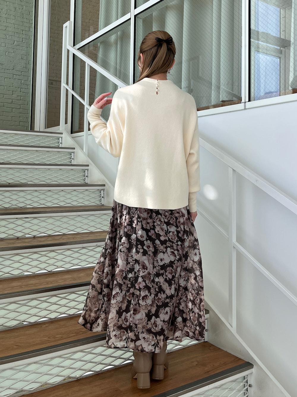 ブラウン系のスカート、ブラウン系のブーツ、ホワイト系のニット/セーターを着用したレディースの冬コーディネートの5枚目の写真