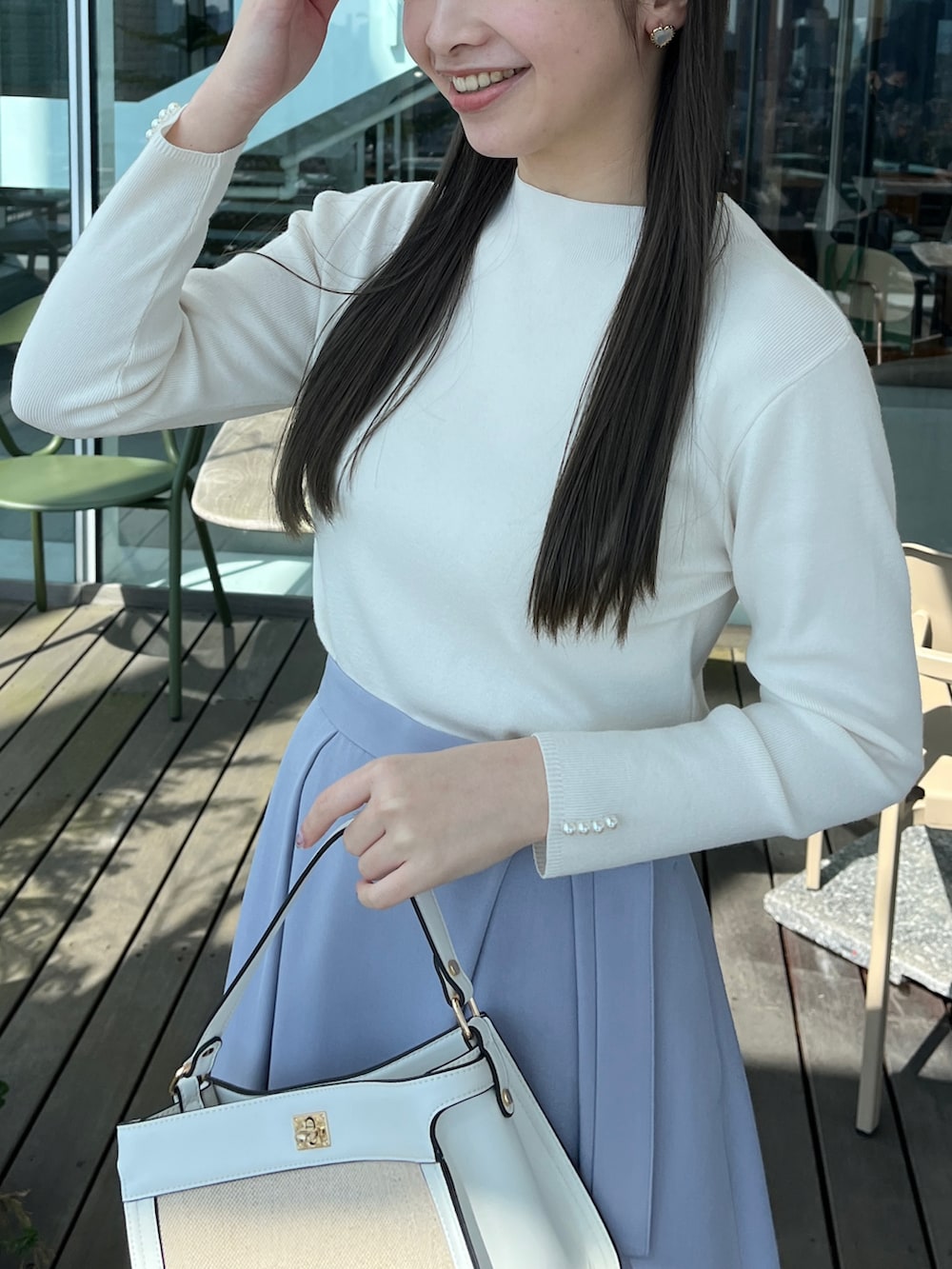 ホワイト系のニット/セーター、ブルー系のスカートを着用したレディースの春コーディネートの4枚目の写真