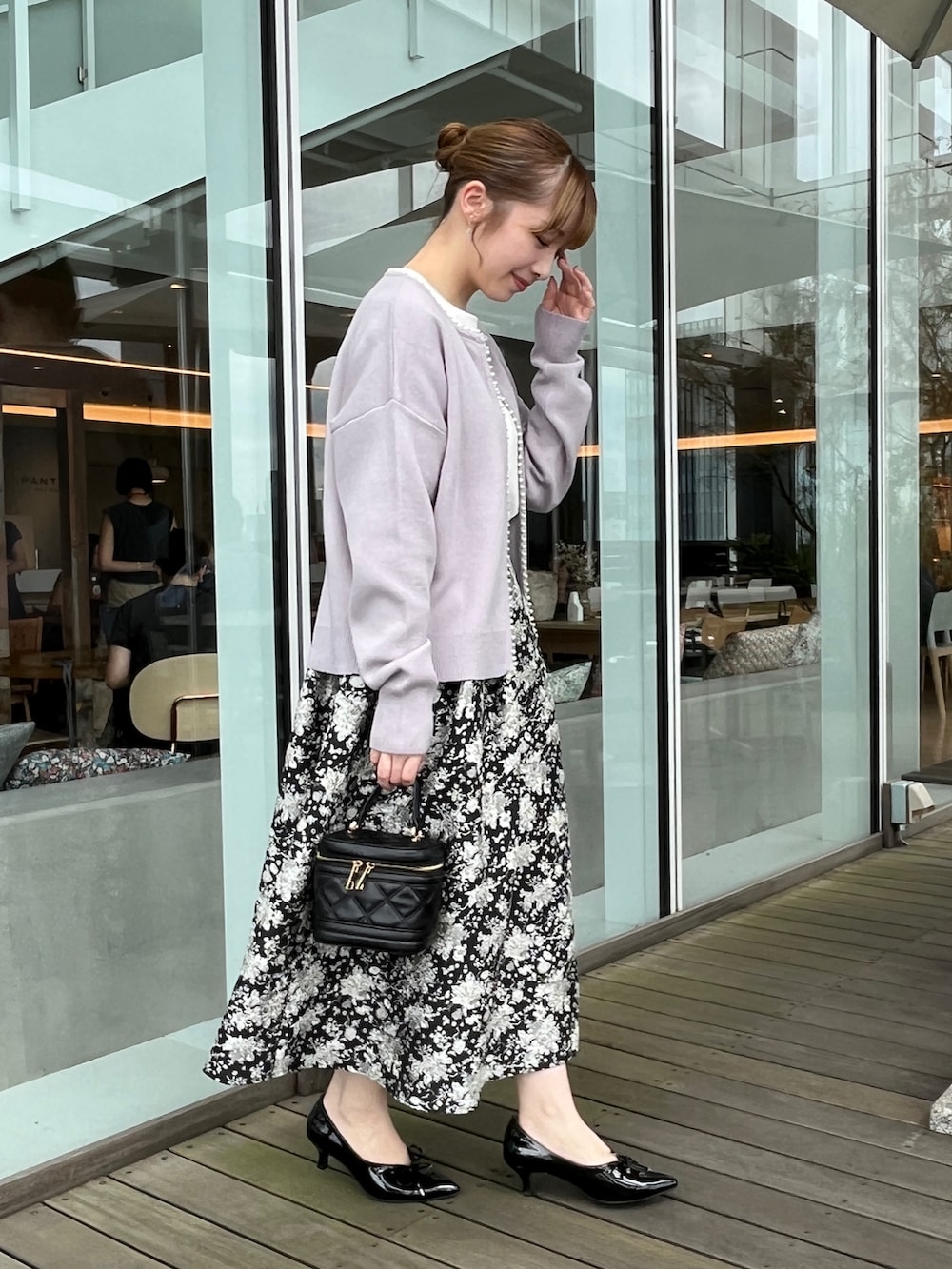 ホワイト系のTシャツ/カットソー、ブラック系のスカート、ブルー系のカーディガン/ボレロを着用したレディースの秋コーディネートの2枚目の写真