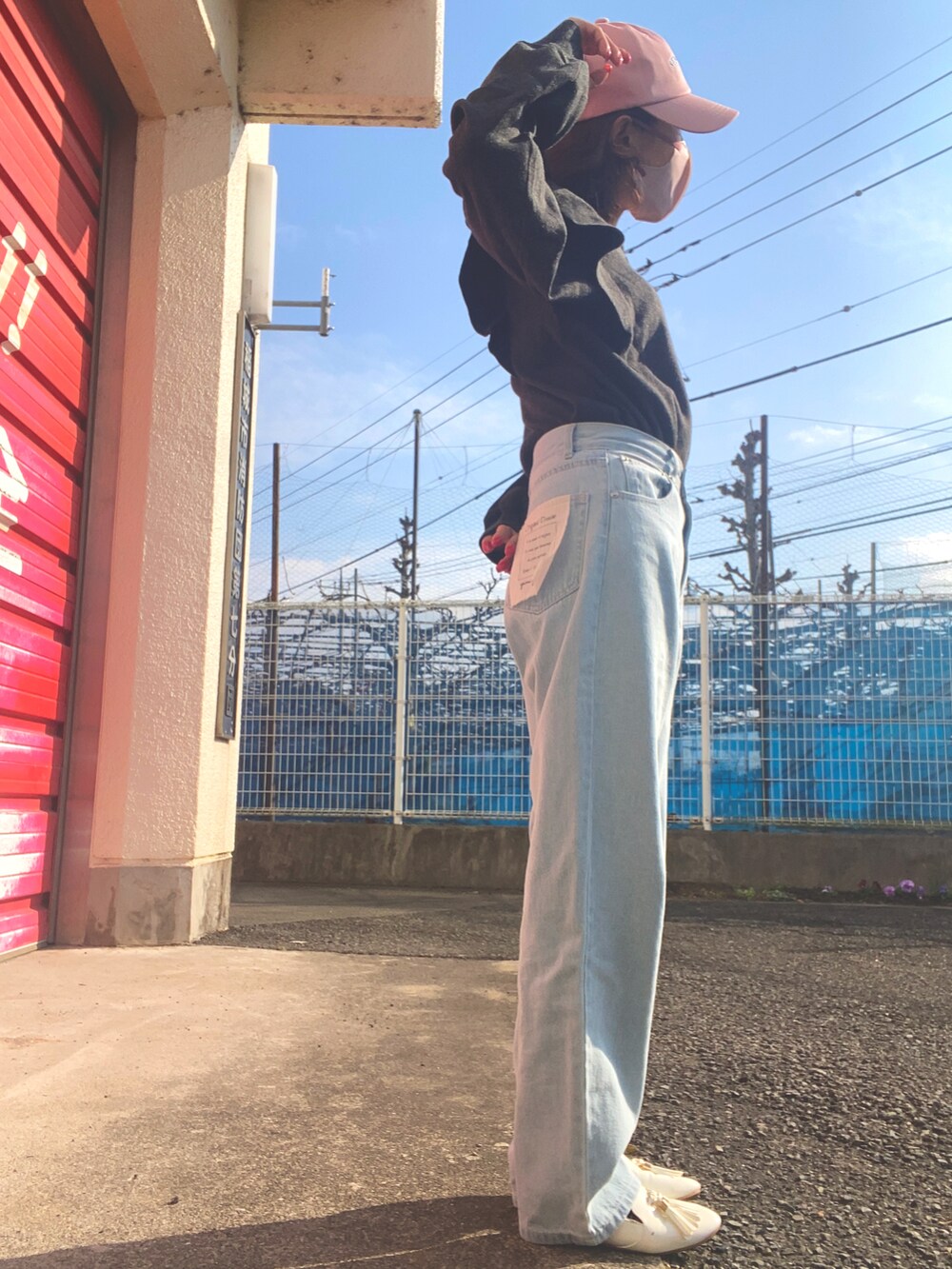 ブラック系のニット/セーター、ブルー系のデニムパンツ、ホワイト系のローファーを着用したレディースの冬コーディネートの2枚目の写真