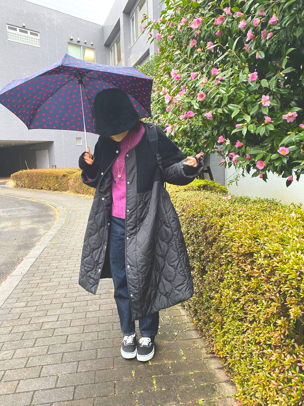 ブラック系のノーカラージャケット、パープル系のニット/セーター、ブラック系のデニムパンツを着用したレディースの冬コーディネートの2枚目の写真