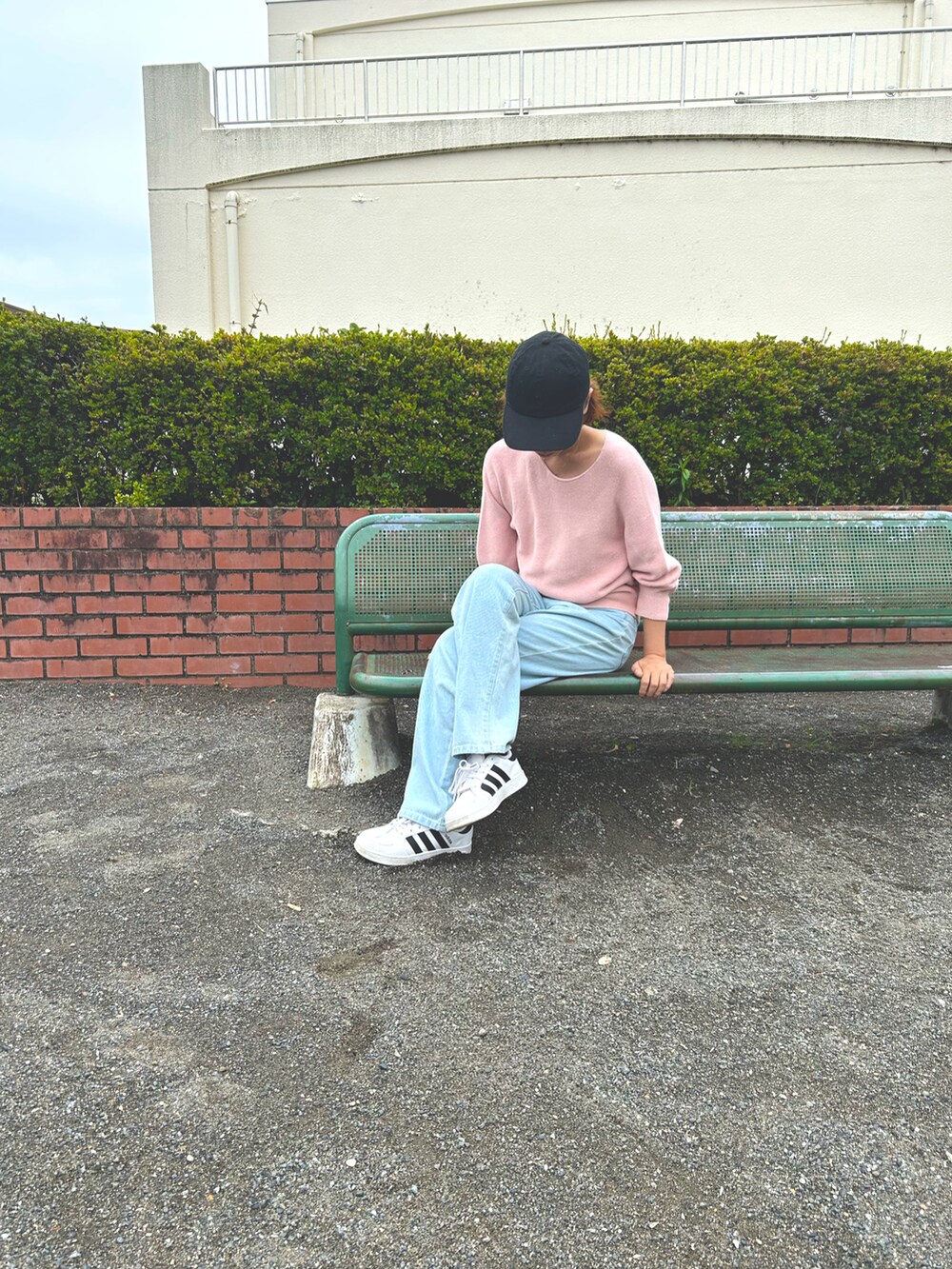 ピンク系のニット/セーター、ブルー系のデニムパンツ、ホワイト系のスニーカーを着用したレディースの夏コーディネートの2枚目の写真