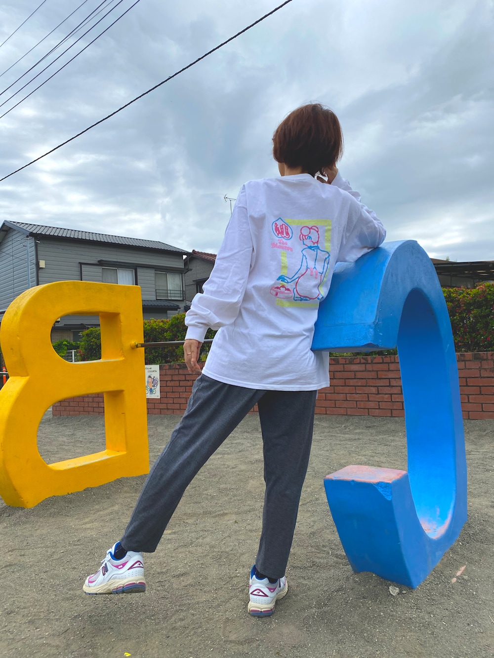 ホワイト系のTシャツ/カットソー、グレー系のパンツ、ホワイト系のスニーカーを着用したレディースの春コーディネートの2枚目の写真