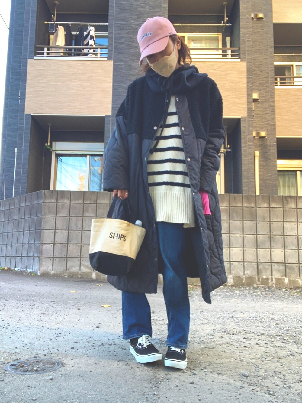 ブラック系のノーカラージャケット、ブルー系のデニムパンツ、ホワイト系のトートバッグを着用したレディースの冬コーディネートの2枚目の写真