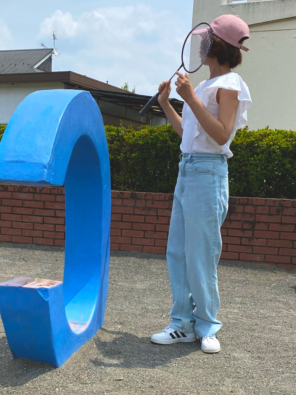 ホワイト系のTシャツ/カットソー、ブルー系のデニムパンツ、ホワイト系のスニーカーを着用したレディースの春コーディネートの2枚目の写真