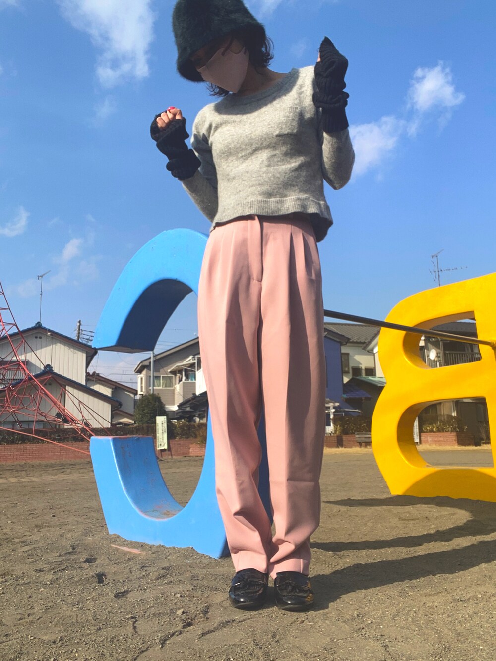 グレー系のニット/セーター、ピンク系のスラックス、ブラック系のローファーを着用したレディースの冬コーディネートの2枚目の写真