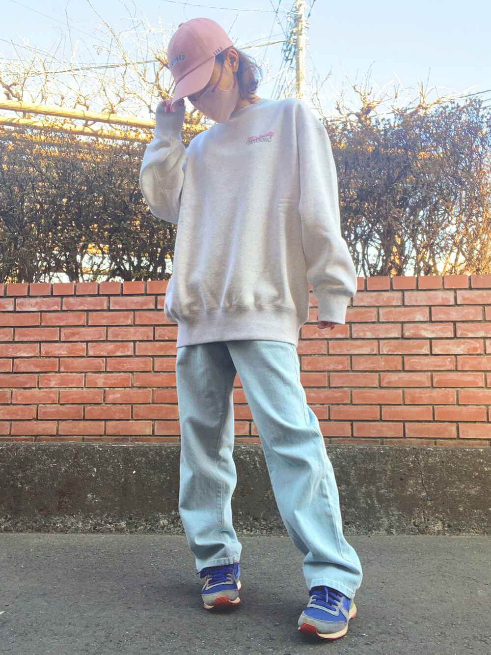 グレー系のスウェット、ブルー系のデニムパンツ、ブルー系のスニーカーを着用したレディースの冬コーディネートの2枚目の写真