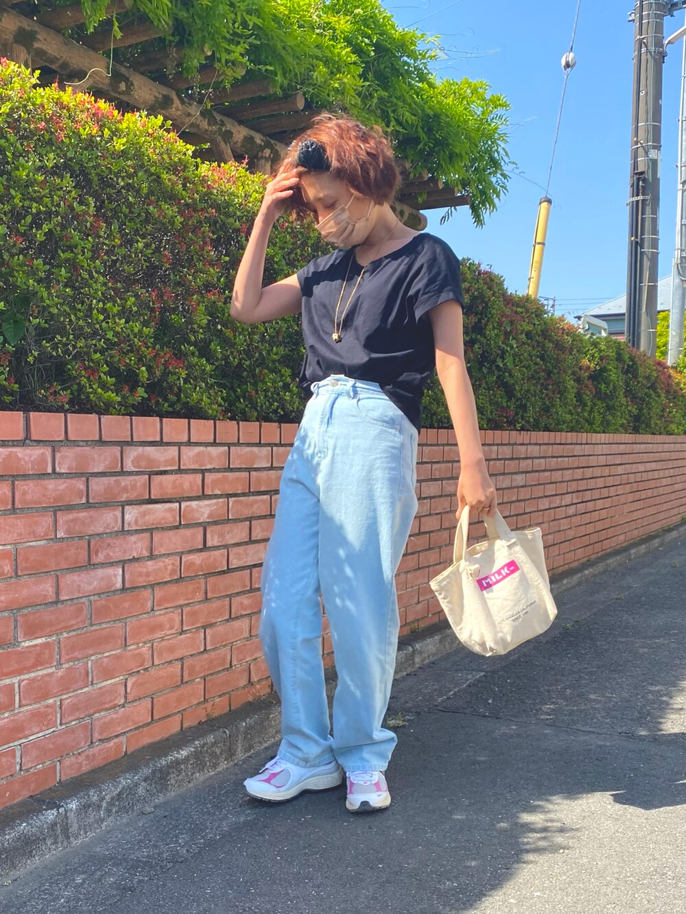 ブラック系のTシャツ/カットソー、ブルー系のデニムパンツ、ホワイト系のトートバッグを着用したレディースの春コーディネートの2枚目の写真