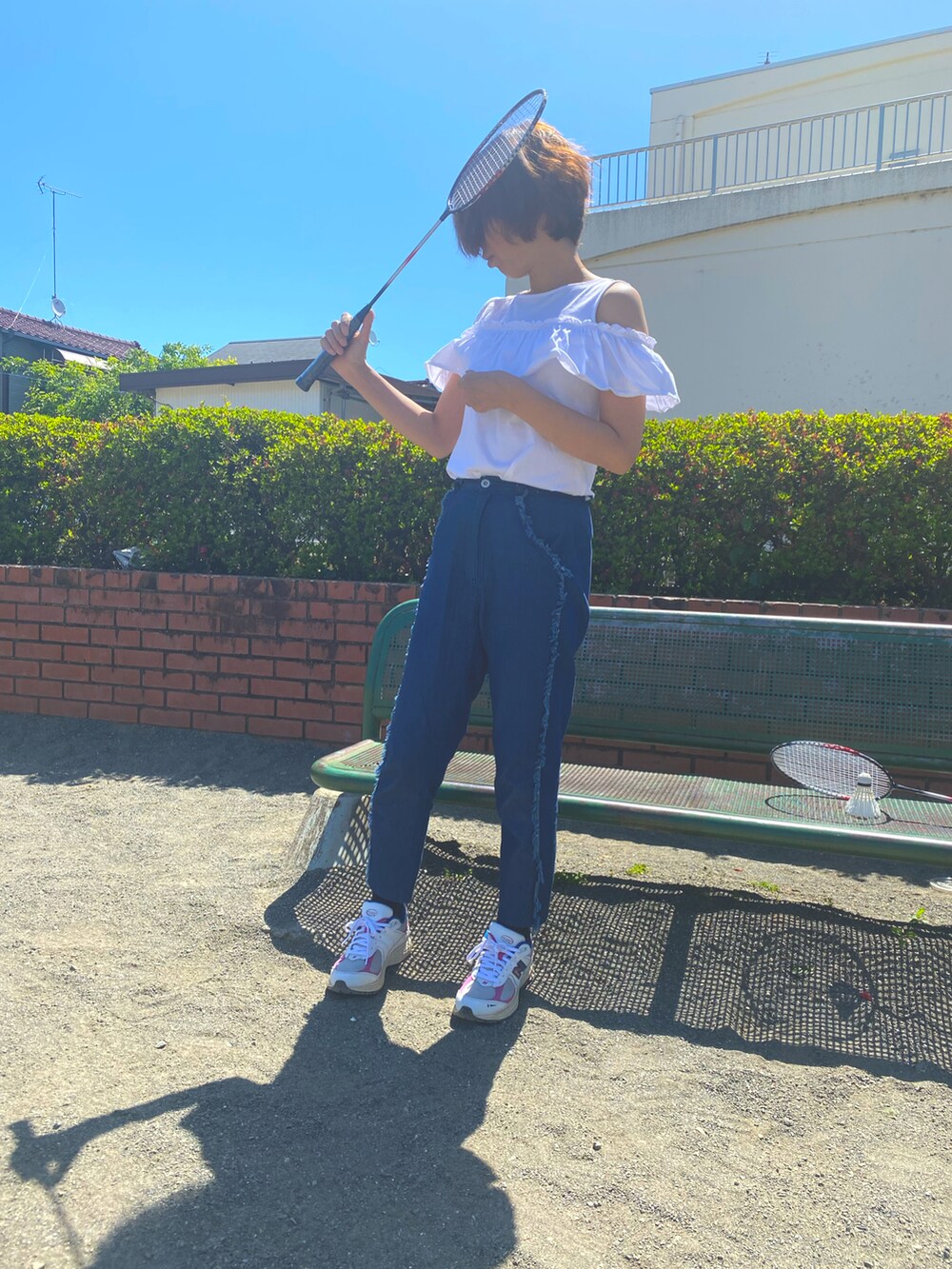 ホワイト系のTシャツ/カットソー、ブルー系のデニムパンツ、ホワイト系のスニーカーを着用したレディースの春コーディネートの3枚目の写真