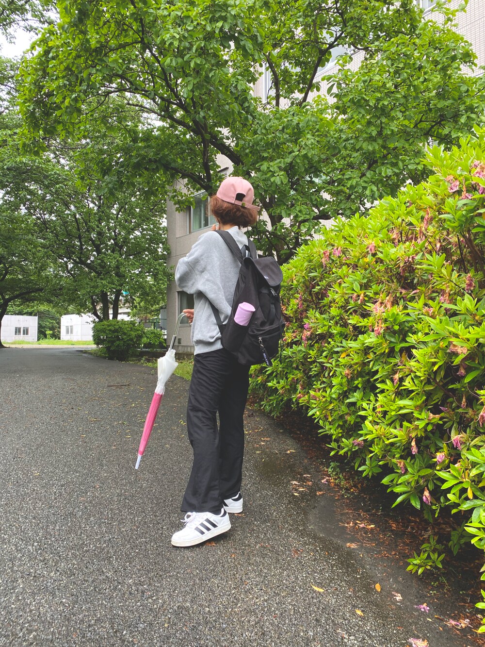 グレー系のスウェット、ブラック系のバックパック/リュック、ブラック系のパンツを着用したレディースの春コーディネートの2枚目の写真