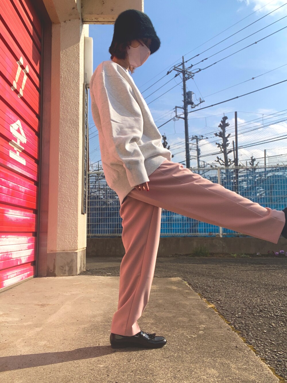 グレー系のスウェット、ピンク系のスラックス、ブラック系のローファーを着用したレディースの冬コーディネートの2枚目の写真