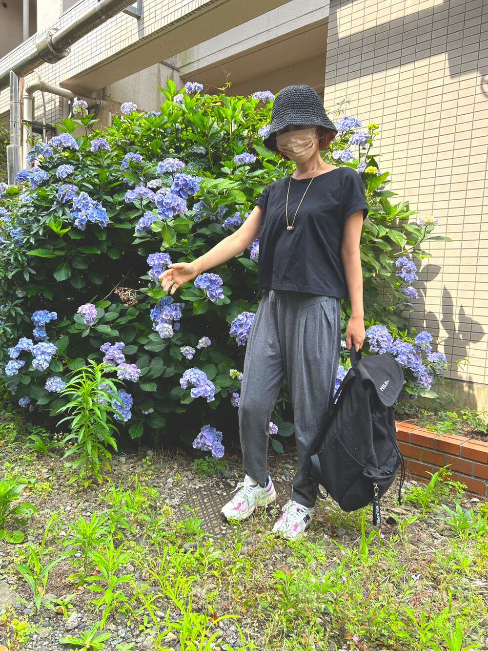 ブラック系のTシャツ/カットソー、グレー系のパンツ、ブラック系のバックパック/リュックを着用したレディースの夏コーディネートの4枚目の写真