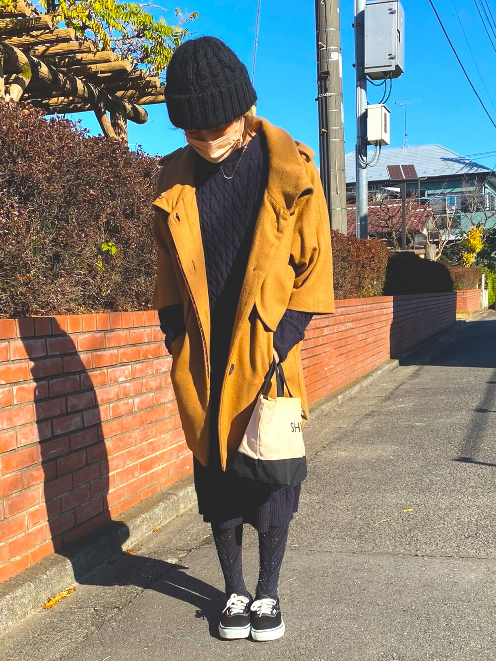 ブルー系のワンピース/ドレス、ブラウン系のジャケット/アウター、ブラック系のスニーカーを着用したレディースの冬コーディネートの2枚目の写真