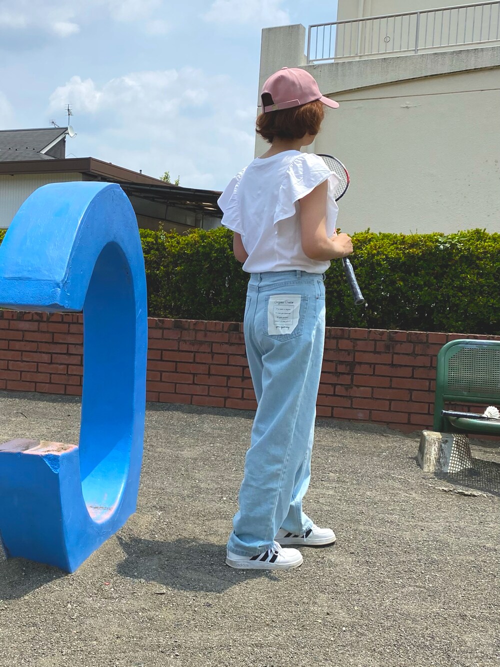 ホワイト系のTシャツ/カットソー、ブルー系のデニムパンツ、ホワイト系のスニーカーを着用したレディースの春コーディネートの3枚目の写真