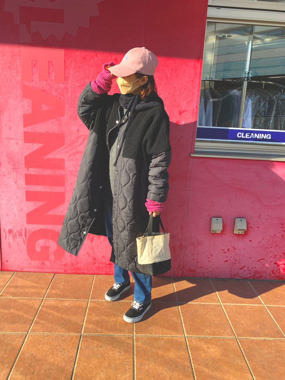 ブラック系のスニーカー、ブルー系のデニムパンツ、ブラック系のノーカラージャケットを着用したレディースの冬コーディネートの2枚目の写真