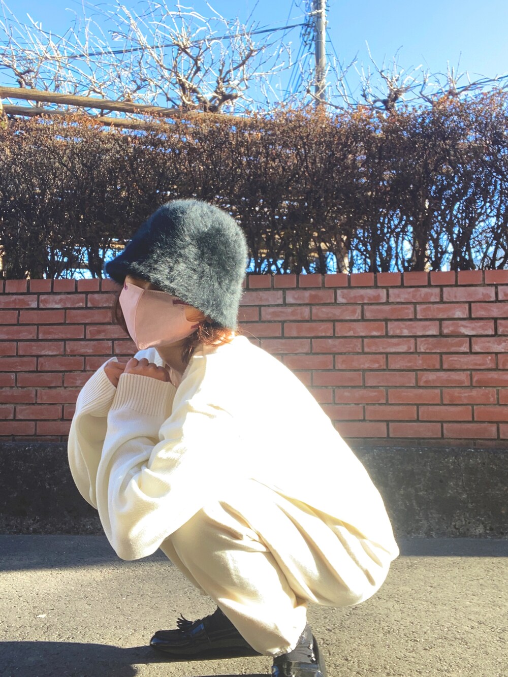 ホワイト系のスウェットパンツ、ホワイト系のニット/セーター、ブラック系のローファーを着用したレディースの冬コーディネートの3枚目の写真