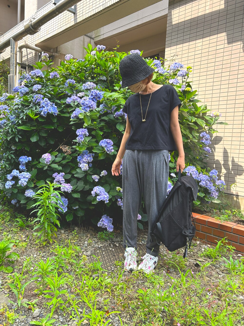 ブラック系のTシャツ/カットソー、グレー系のパンツ、ブラック系のバックパック/リュックを着用したレディースの夏コーディネートの3枚目の写真