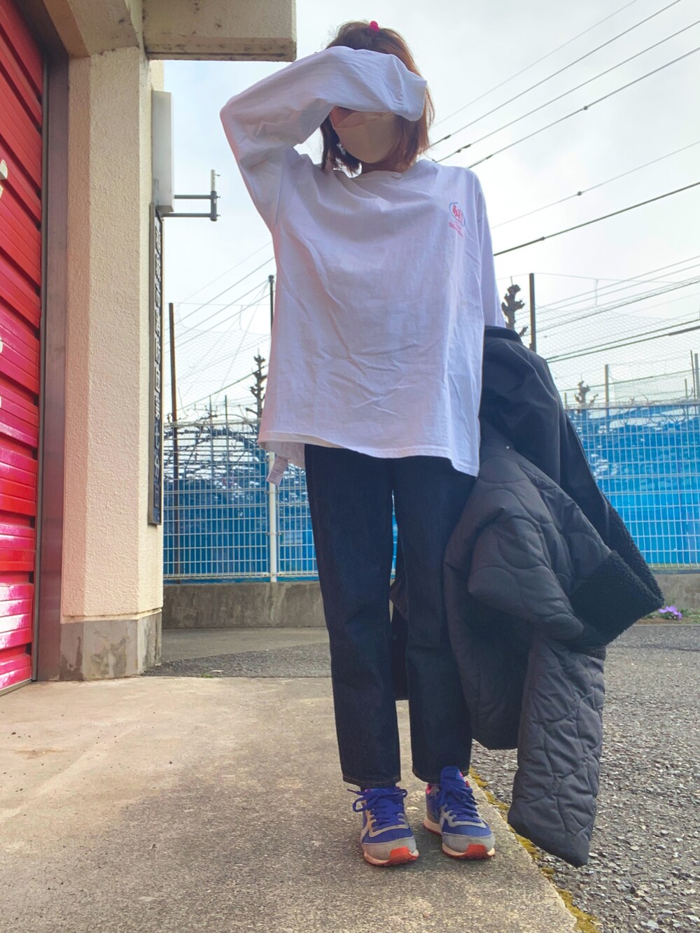 ホワイト系のTシャツ/カットソー、ブラック系のデニムパンツ、ホワイト系のトートバッグを着用したレディースの冬コーディネートの2枚目の写真