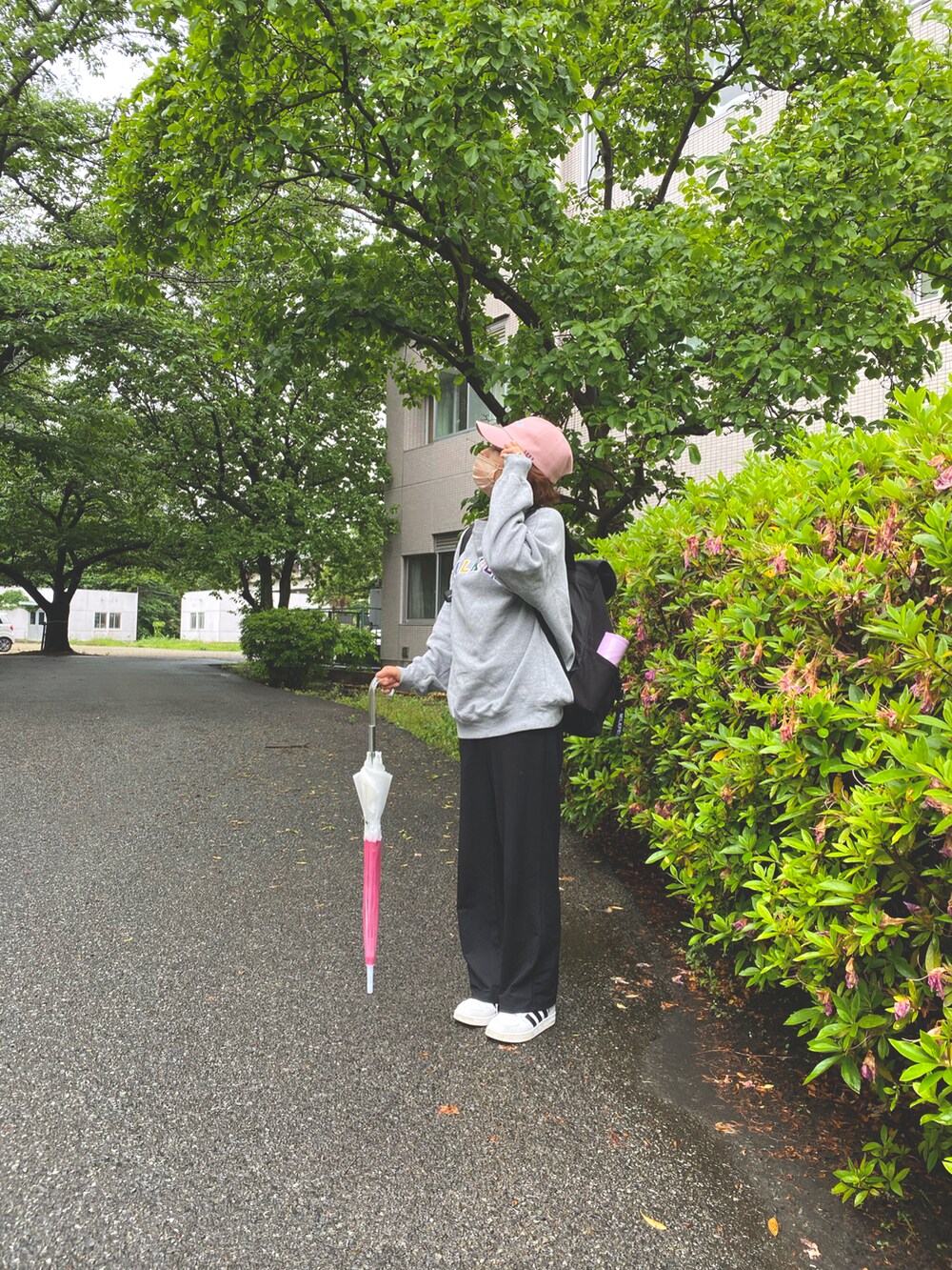 グレー系のスウェット、ブラック系のバックパック/リュック、ブラック系のパンツを着用したレディースの春コーディネートの3枚目の写真