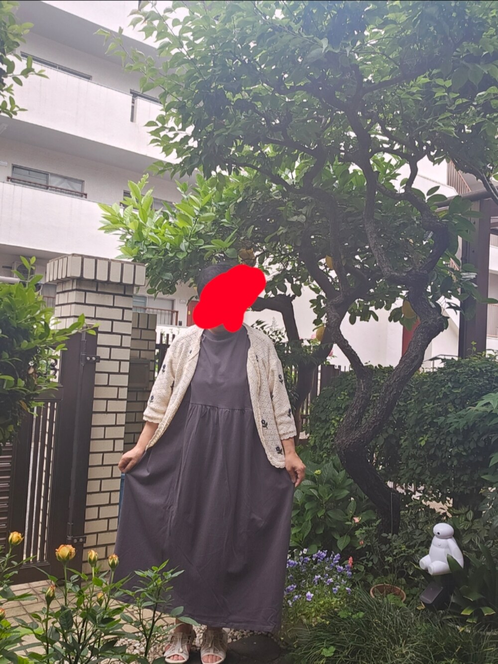 グレー系のワンピース、ホワイト系のカーディガン/ボレロを着用したレディースの春コーディネートの2枚目の写真