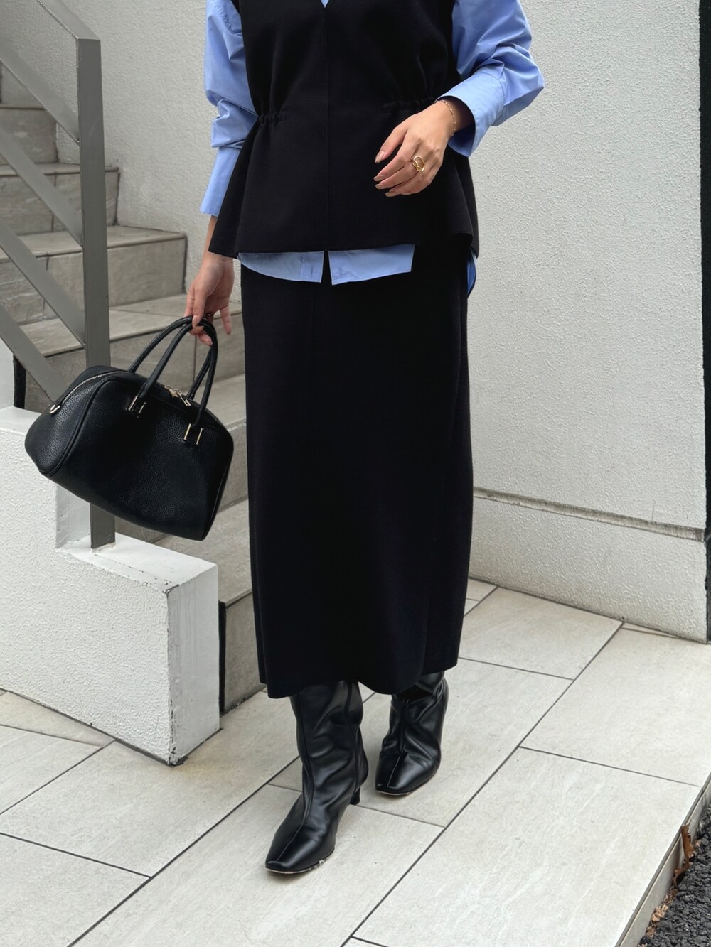ブラック系のベスト、ブルー系のシャツ/ブラウス、ブラック系のショルダーバッグを着用したレディースの秋コーディネートの6枚目の写真