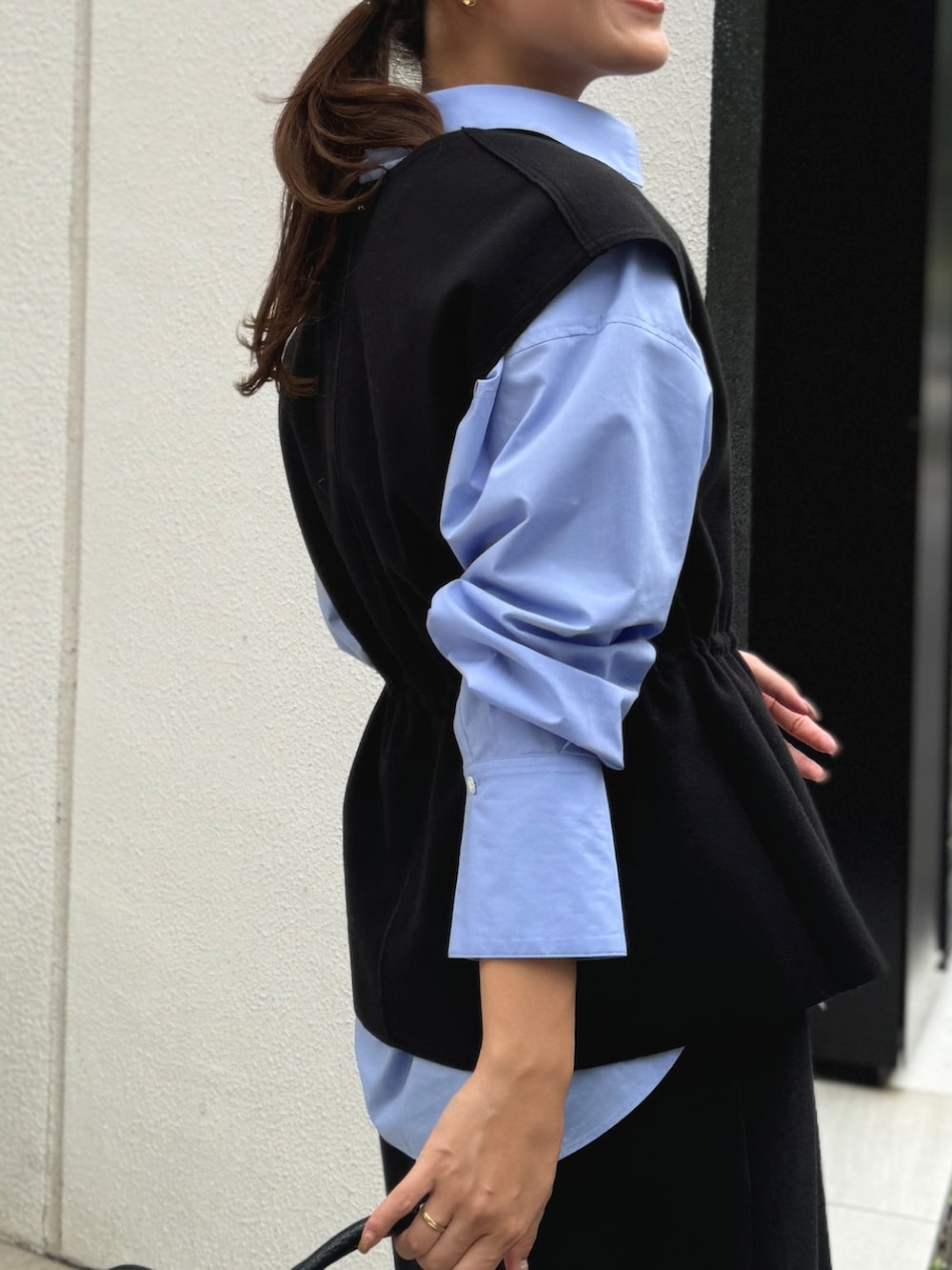 ブラック系のベスト、ブルー系のシャツ/ブラウス、ブラック系のショルダーバッグを着用したレディースの秋コーディネートの4枚目の写真