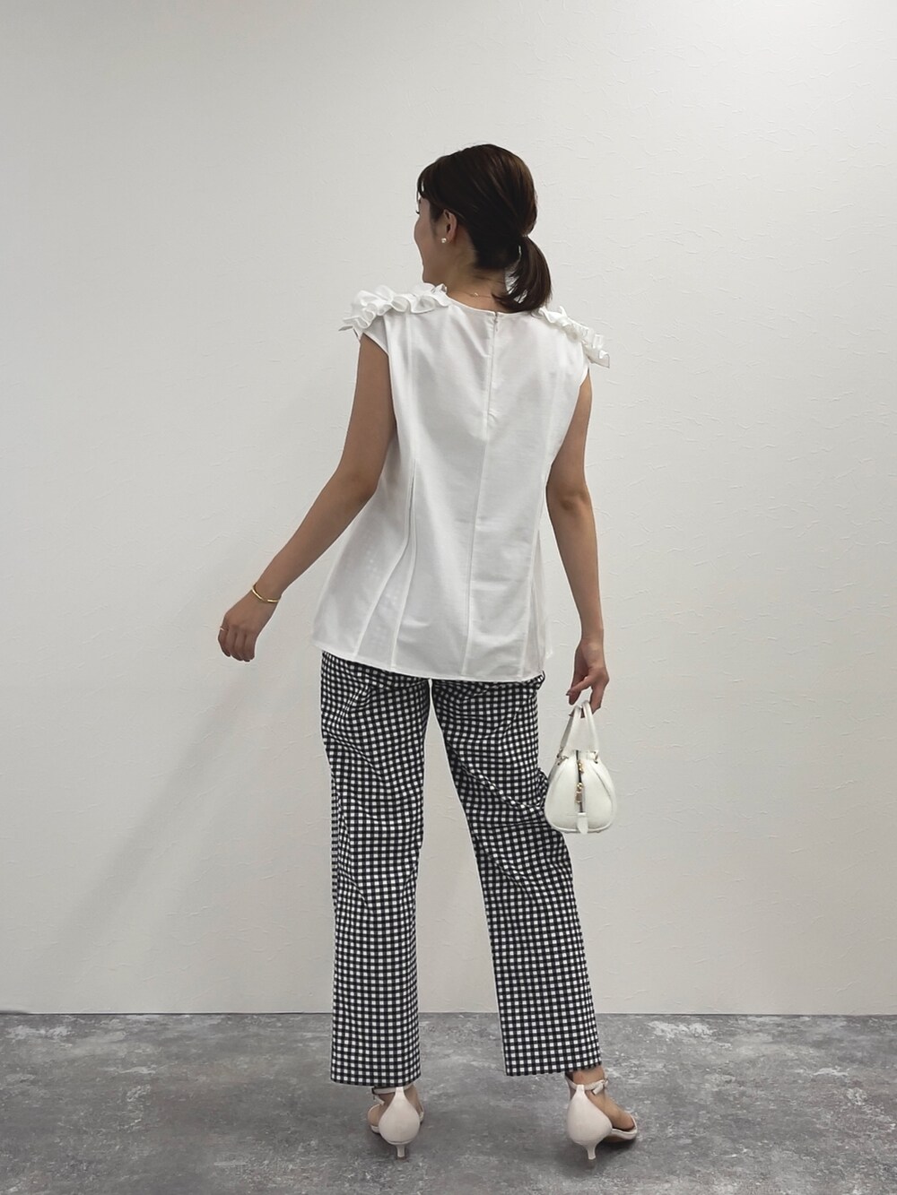 ブラック系のその他パンツ、ホワイト系のTシャツ/カットソー、ホワイト系のボストンバッグを着用したレディースの春コーディネートの3枚目の写真