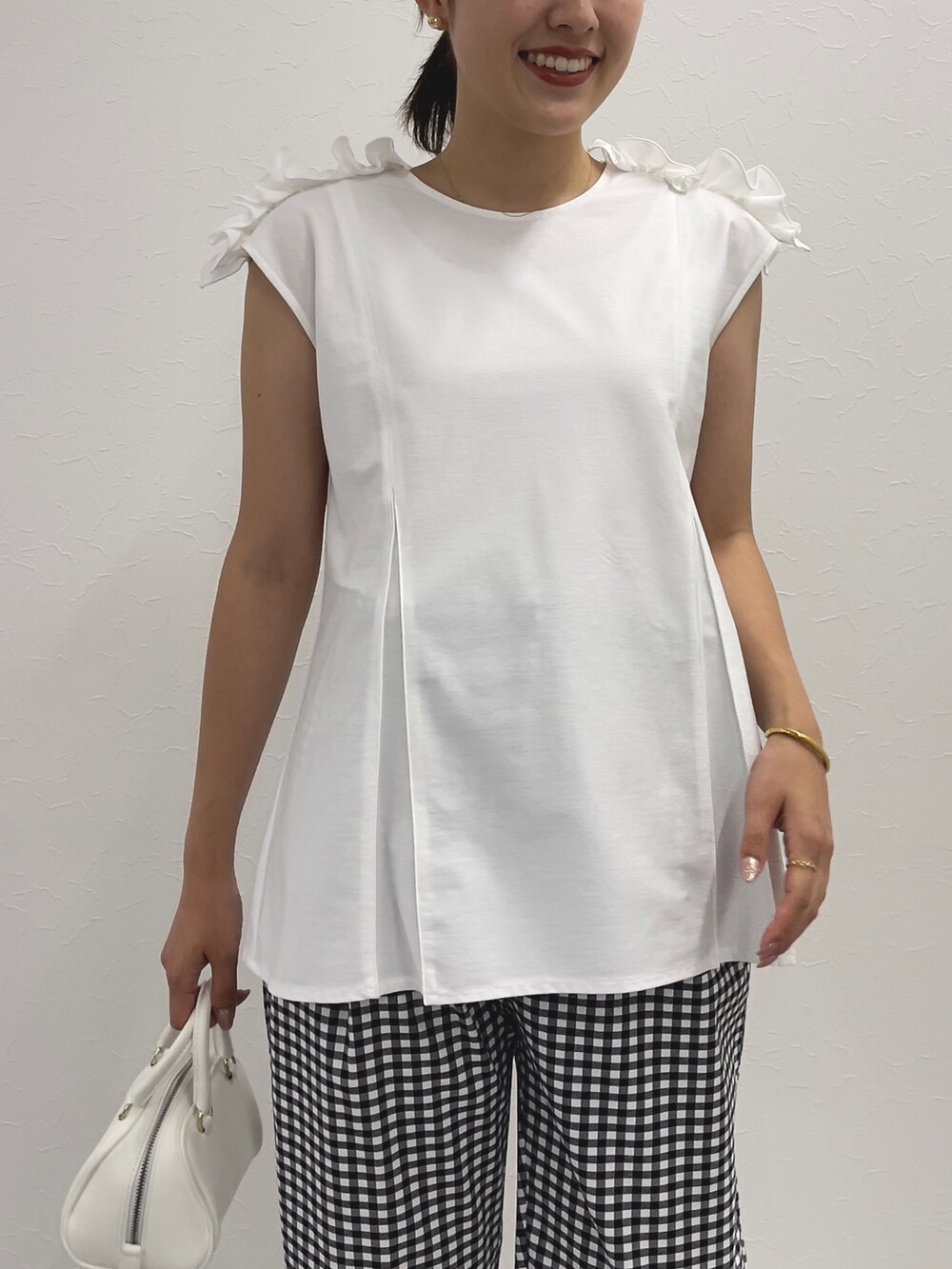 ブラック系のその他パンツ、ホワイト系のTシャツ/カットソー、ホワイト系のボストンバッグを着用したレディースの春コーディネートの5枚目の写真