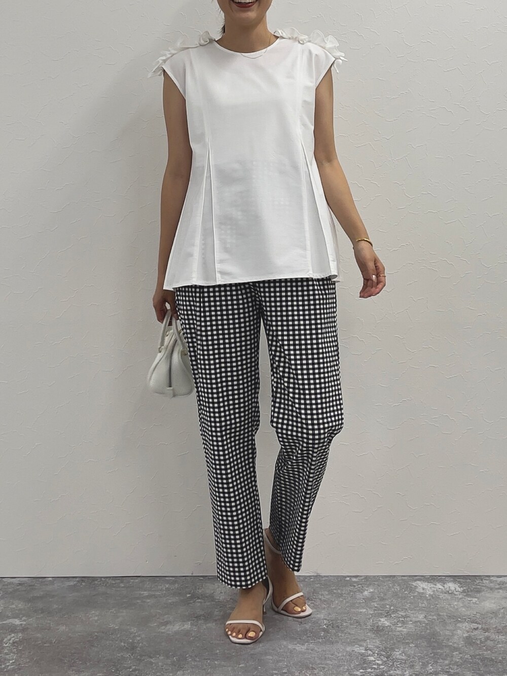 ブラック系のその他パンツ、ホワイト系のTシャツ/カットソー、ホワイト系のボストンバッグを着用したレディースの春コーディネートの2枚目の写真